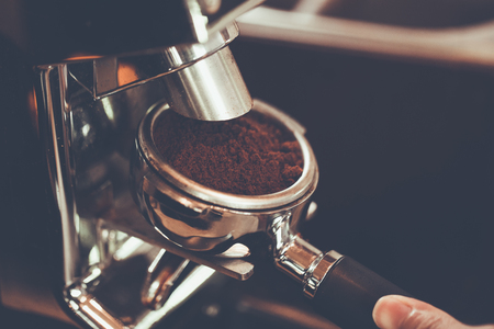 Hand of Barista put a portafilter to espresso machine for brewing coffee,color vintage style ,Thailandの写真素材