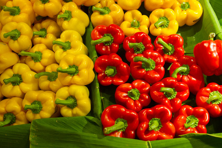 Assorted bell peppers in various colors on the banana leaf at fresh market, autumn vegetablesの写真素材