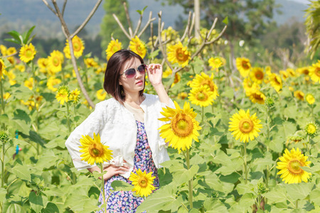 Woman wearing sunglasses in a field of sunflowersの写真素材
