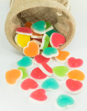 colorful heart sign jelly spread from basket on white backgroundの写真素材