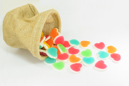 colorful heart sign jelly spread from basket on white backgroundの写真素材