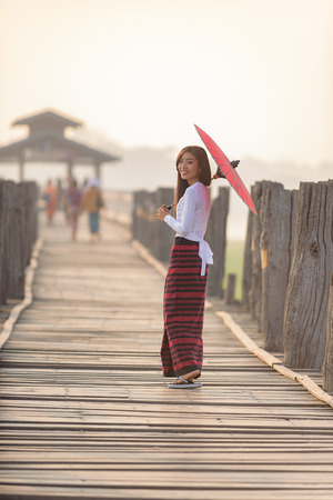 Portrait of smiling beautiful young burmese woman with the traditional dress in u bein bridge mandalay myanmarの写真素材