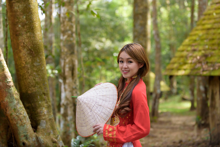 Beautiful vietnamese girl in traditional dress (ao dai) in a parkの写真素材