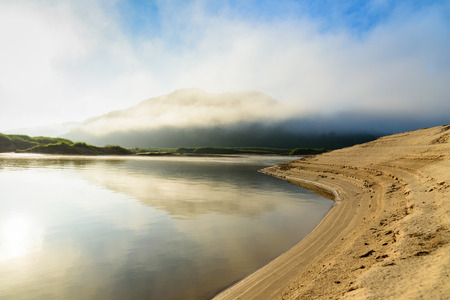 beautiful curve river with mountain cloudy fog and blue sky background at sunriseの写真素材