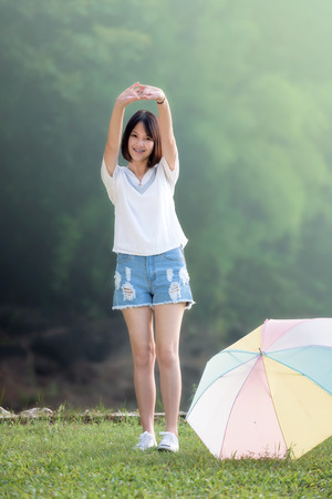 Beautiful young girl doing exercises outdoor. Beautiful young girl warm up outdoor in morning during sunriseの写真素材