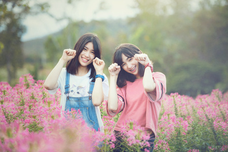 Beautiful Caucasian girls smiling with happiness in cosmos flower fieldの写真素材