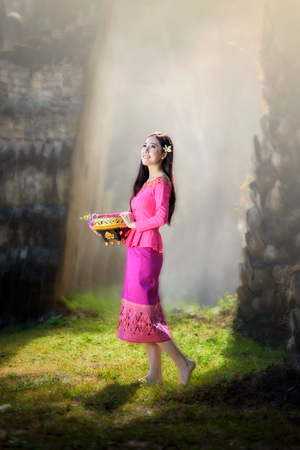 beautiful Asian women (Laos)  in pink traditional costume with stunning light backgroundの写真素材