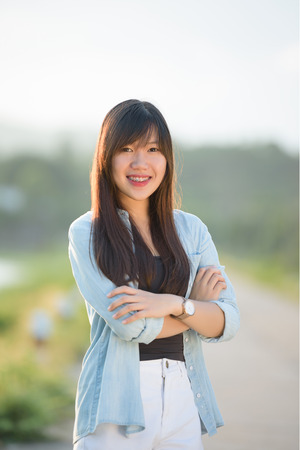 beautiful girl portrait during sunset smiley happy with nature backgroundの写真素材