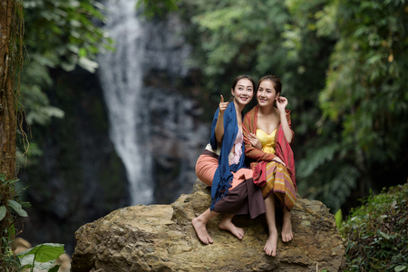 portrait of beautiful Asian woman in traditional costume with water fall backgroundの写真素材