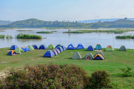 camping and tents nearby river in morningの写真素材