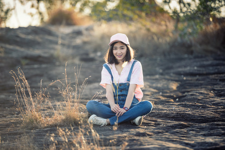 beautiful caucasian girl holding grass flower in hand smiling with beautiful lightの写真素材