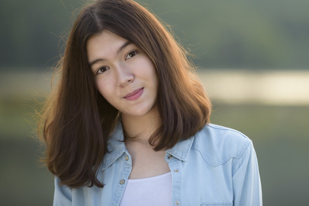 beautiful girl portrait during sunset smiley happy with nature backgroundの写真素材