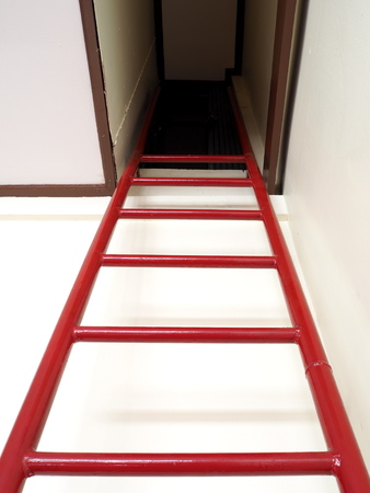 Red ladder to door from underground roomの写真素材