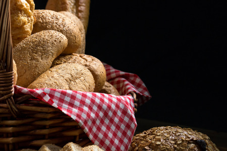 Close up of round bun bread in the basket on black background