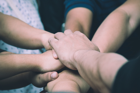 Teamwork concept; many people standing hands together in field before starting competition gameの写真素材