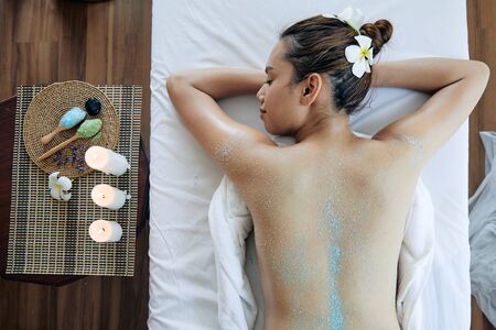 Asian young beautiful woman get salt spa treatment on back; photo by top viewの写真素材