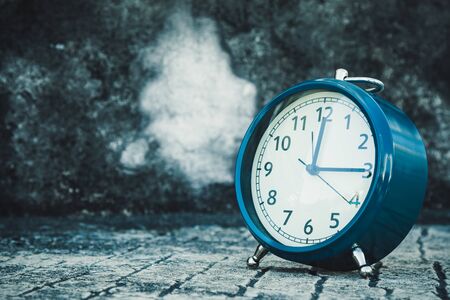 Retro blue clock place on the concrete stand and show time at noon for lunchの写真素材