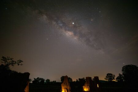 Milky way rising up parallel with ancient stone cliff; photo by median stack techniqueの写真素材