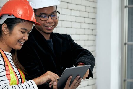 Chief Engineer check data in taplet together with Safety officer for construction site