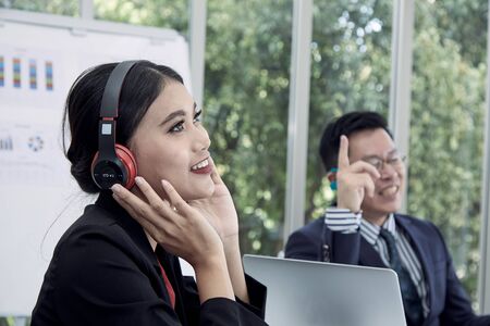 Manager and secretary listening to music for relaxation after the sale report meetingの写真素材