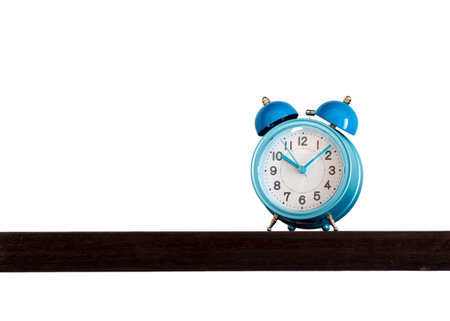 Blue alarm retro and vintage classic design clock placing on wooden shelf with ten o'clock isolated...