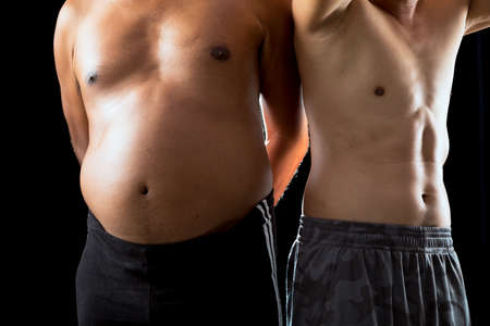Two Asian sporty man in native shorts standing together comparing body muscle motivation on black...