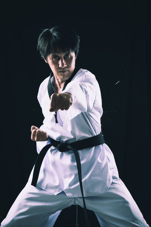 Black Red Belt TaeKwonDo Karate male athlete man show traditional Fighting poses punch on black backgroundの写真素材