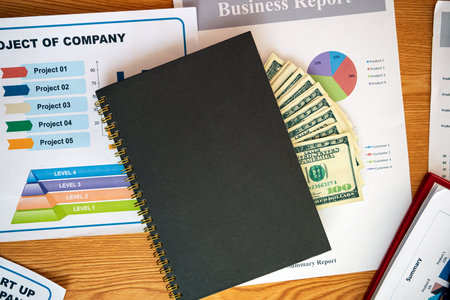 Business Project Corruption: Still Life of Dollar Bank Notes in Notebook over Project plan and ...