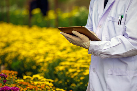 Close-up of an agricultural researcher wearing a lab coat and gloves, using a tablet in a vibrant...