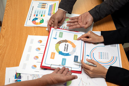 Close-up of professionals analyzing startup business strategy with charts and graphs during a...