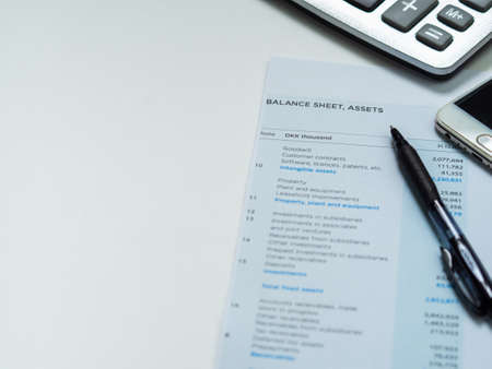 Financial statement concept:Balance sheet report assets paper report with smart phone calculator and...