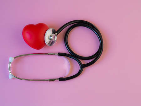 Red heart with stethoscope on pink background, heart health, heart disease, health insurance concept, world health day, doctor days.の写真素材