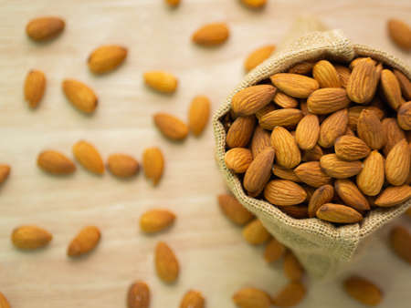 Almond (raw almond) in bag on blur wood table background.の写真素材