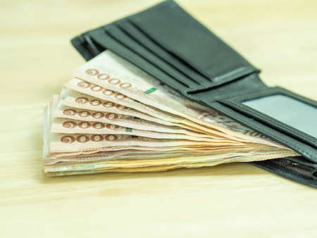 Hands hold Thai money,kind of thousand bank note in wallet.の写真素材