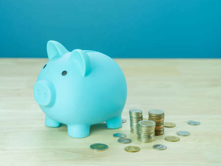 Blue  piggy bank with blur of coins. The concept of saving money or savings, investmentの写真素材