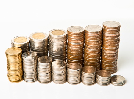 top view of stacks of coins increasing in height, on white  backgroundの写真素材