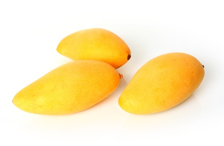 Three ripe golden mangoes on white backgroundの写真素材