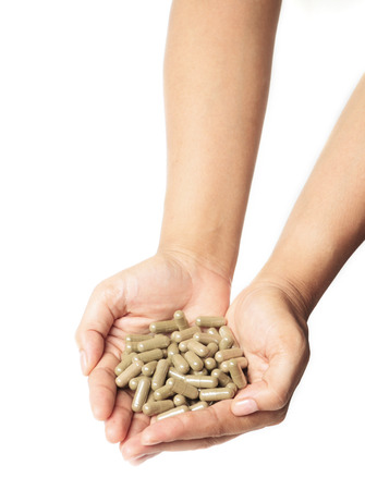 Hands with a pills herb on white backgroundの写真素材