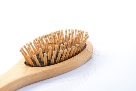 Wooden comb brush with lost hair, isolated on white background           の写真素材