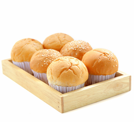 Fresh buns on a wooden tray isolated over white background.の写真素材