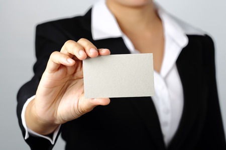 business woman showing a blank empty name card on gray background, clipping pathの写真素材