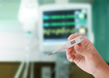 Close up of thermometer showing high temperature in woman hand with drop of saline solution and...