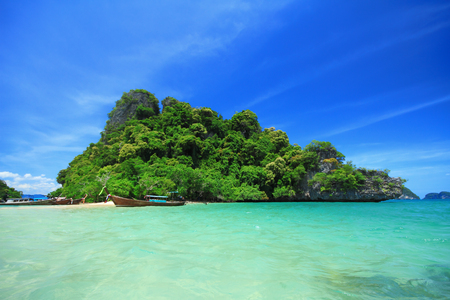 Long tail boats by the shore at Kra bi Andaman sea of Thailand against beautiful clear blue sky.の写真素材