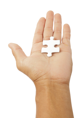 Male hand holding white puzzle isolated on white background, clipping path.の写真素材