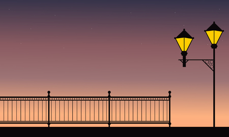 Silhouette of fence with street lamp at nightのイラスト素材
