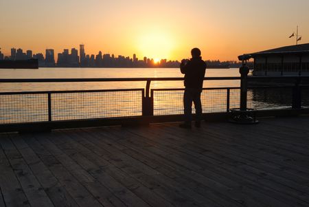man taking photos at sunsetの写真素材