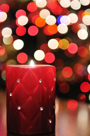 Red candle with christmas lights in backgroundの写真素材