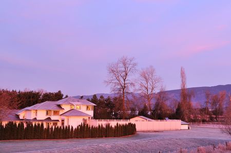 Farmhouse in contryside at winter sunriseの写真素材