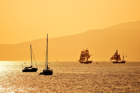tall ships and yachts near English Bay at sunsetの写真素材
