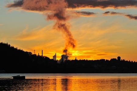 Oil refinery by the water at sunset